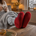 Chaussons chauffants au micro-ondes rouges, portés sur une table basse